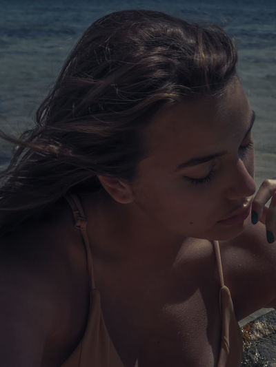 Close-up portrait of woman looking at beach
