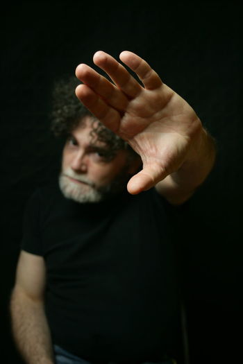Portrait of man hand against black background