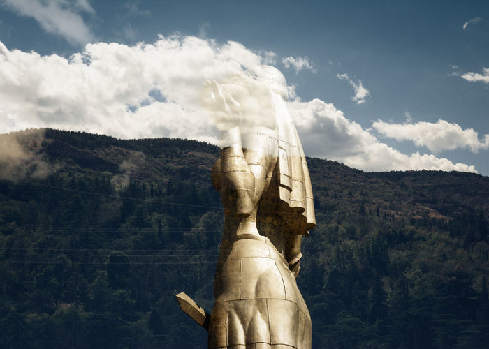Double exposure image of statue and mountain