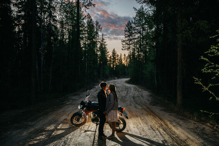 People riding motorcycle on road in forest