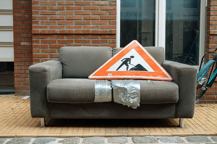 Building site information sign on sofa in front of wall