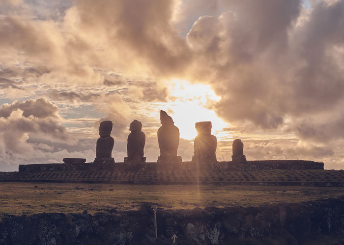 Silhouette of moai statues at sunset on easter island chile