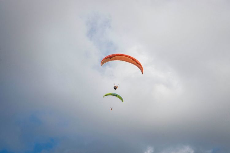 Low angle view of person paragliding against sky