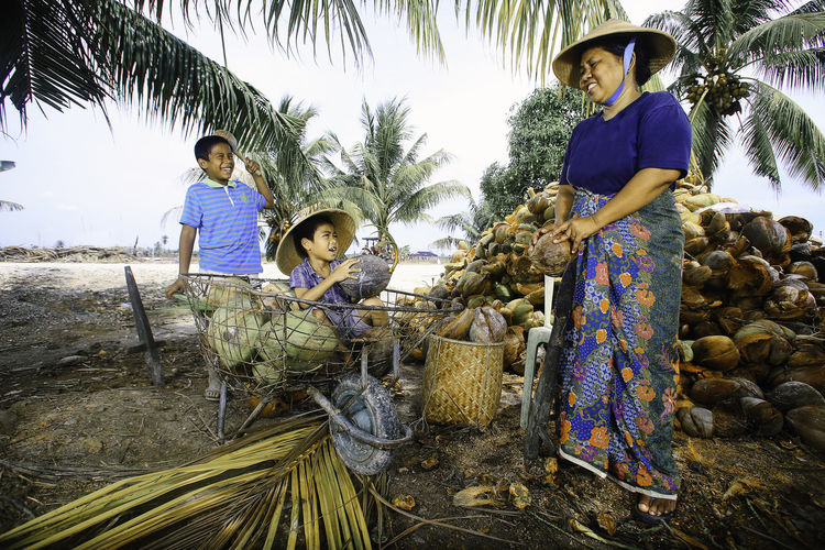 Smiling mother with kids holding coconuts