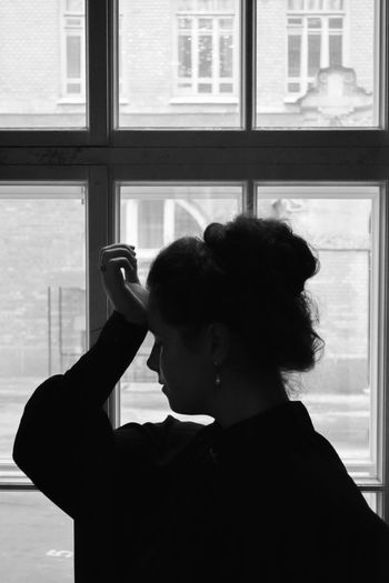 Rear view of woman looking at window