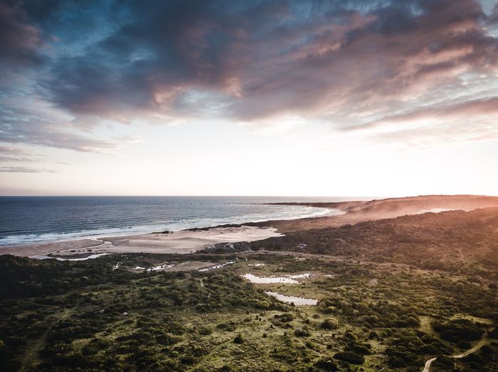 Scenic view of beach against sky during sunset