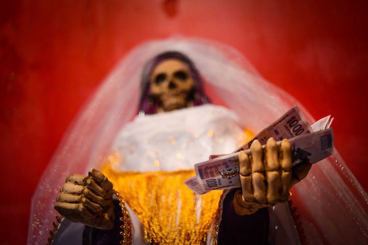 Skeleton in bride costume holding money