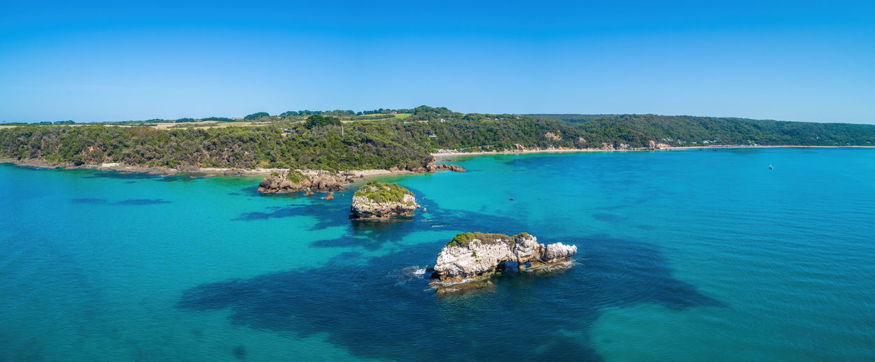 Aerial panorama of scenic ocean coastline with rocks and shallow turquoise water near walkerville 