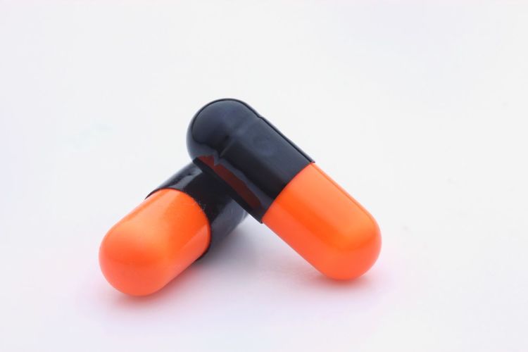 Close-up of orange pencils over white background