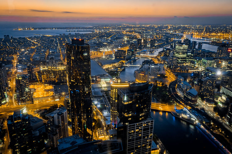 Aerial view of illuminated city at sunset