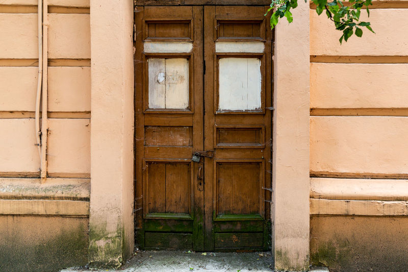 The old abandoned brown door is locked