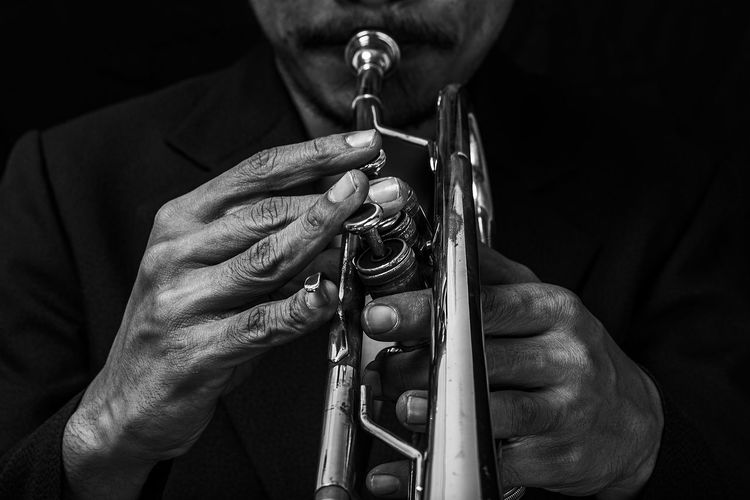 Midsection of man playing trumpet
