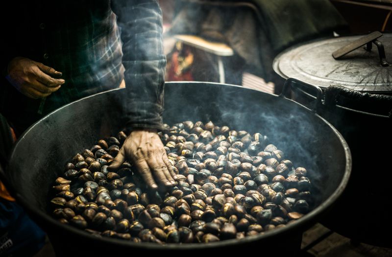 Close-up of man roasting chestnuts