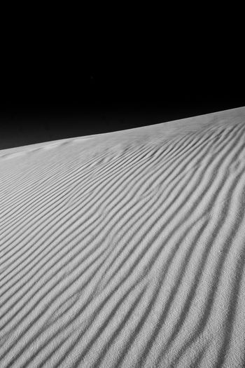 Surface level of sand dune against dark sky