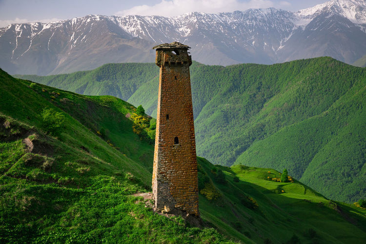 View of tower against mountain range. old ancient historical towers of the chechens
