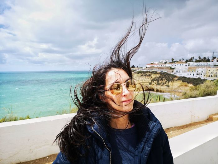 Portrait of woman in sunglasses against sea 