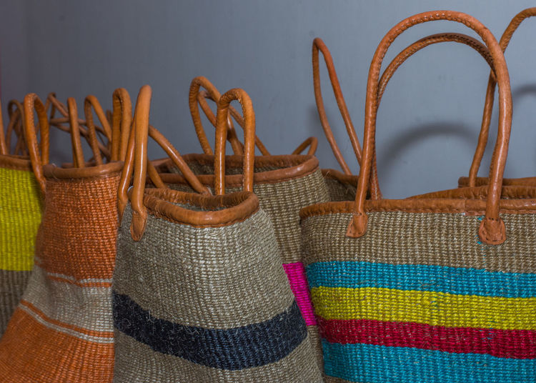 Close-up of colorful bags for sale by wall in shop