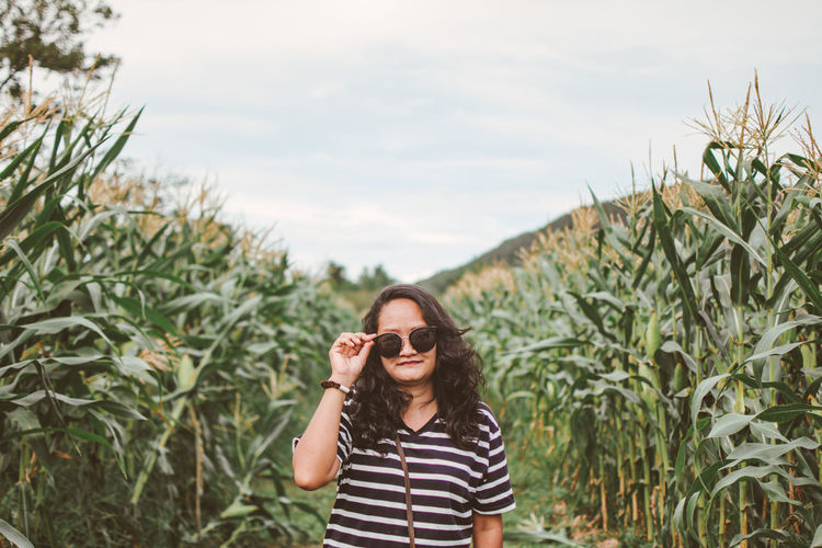 Portrait of mid adult woman wearing sunglasses while standing at farm