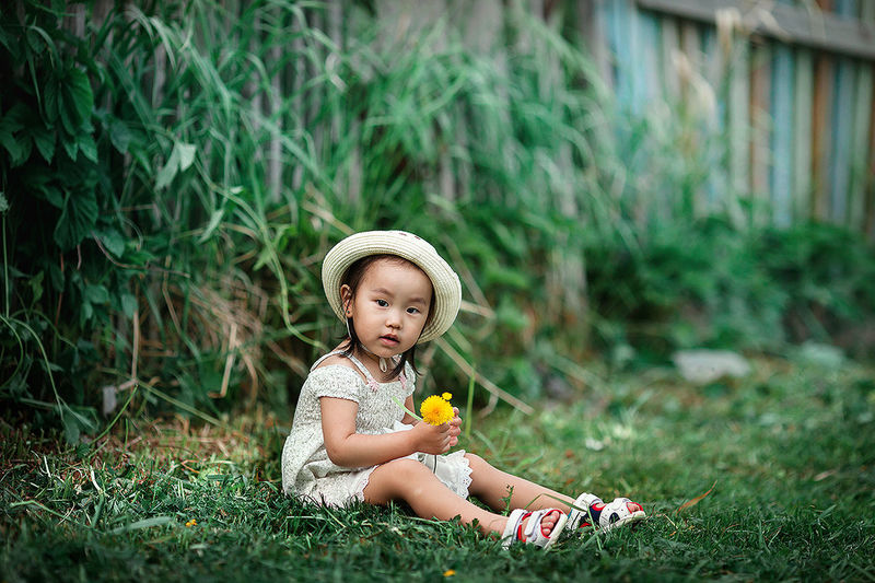 Cute baby girl sitting on grass