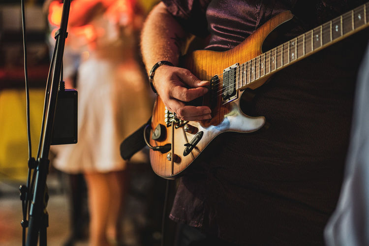 Midsection of man playing guitar