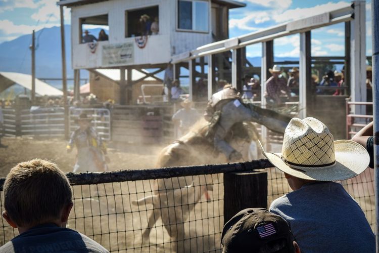 Cowboys looking at rodeo bullfighters during competition