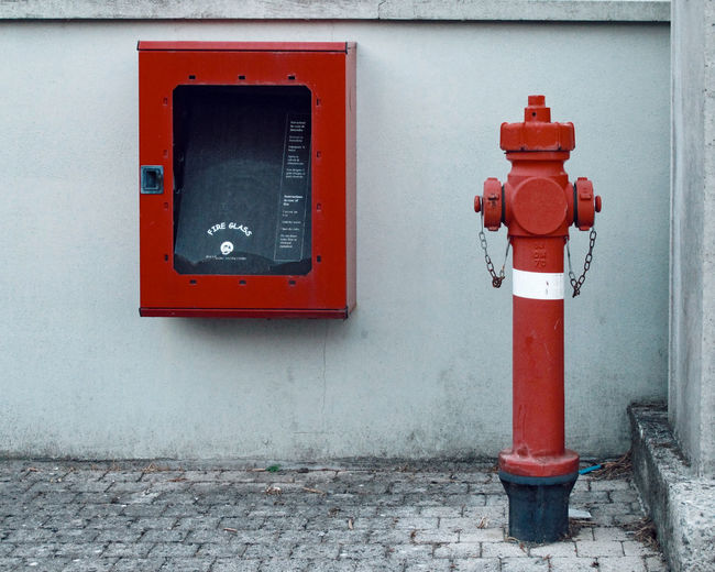 Red fire hydrant against wall