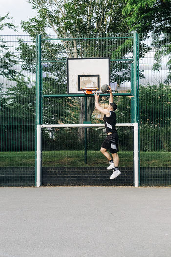 Athlete dunking basketball in hoop at court