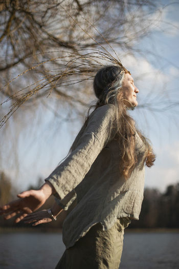 Close up authentic woman with willow crown enjoying warm sunlight portrait picture