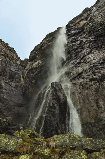Low angle view of waterfall on rocks