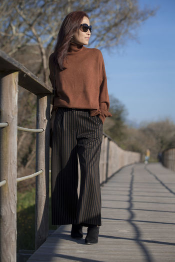 Rear view of woman walking on footpath