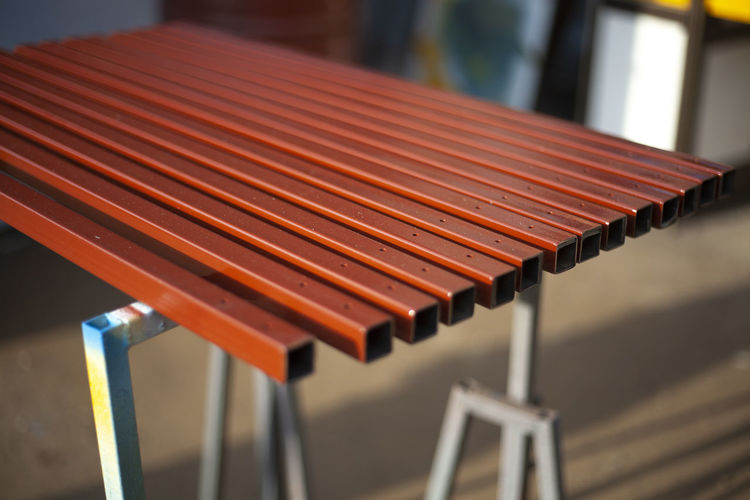 Painted metal profile. steel in brown paint. work in the workshop. sliced steel square pipes. 