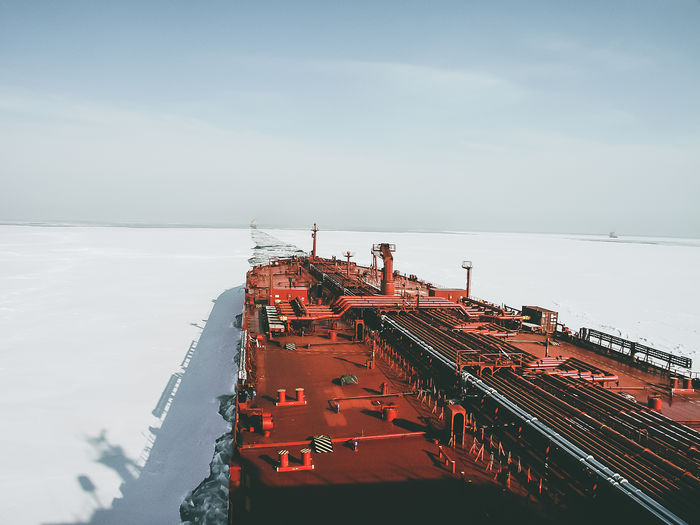 View from the captain's bridge to the deck of a large crude oil tanker sailing among the ice