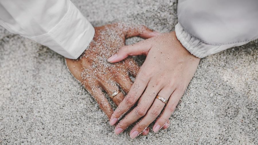 Cropped hand of person on sand