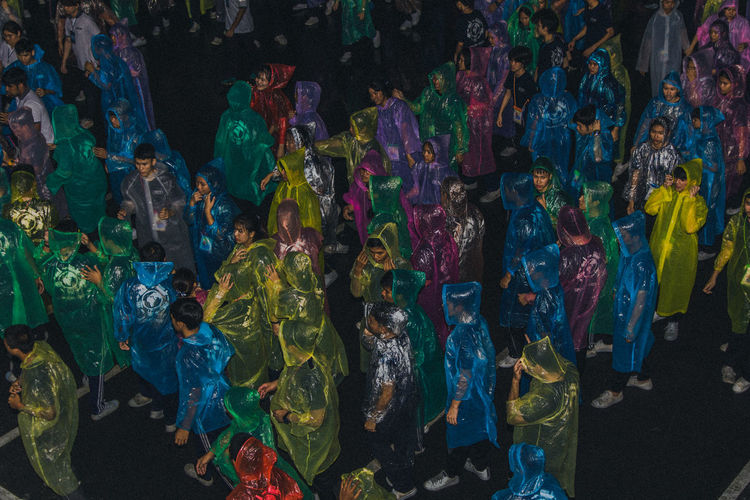 High angle view of people wearing raincoats while standing on road during rainy season