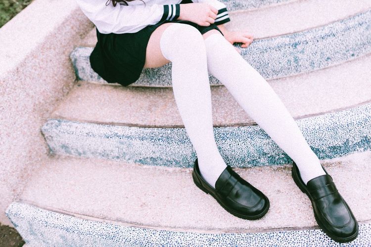 Low section of teenage girl wearing black shoes
