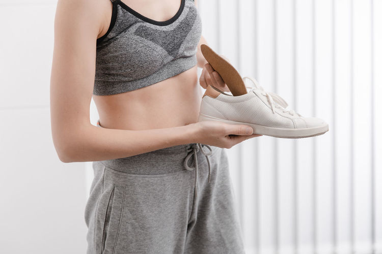 Midsection of woman holding shoe