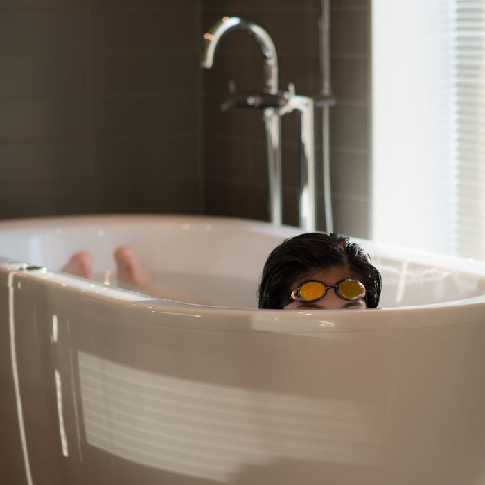 Woman in bathtub with swimming goggles