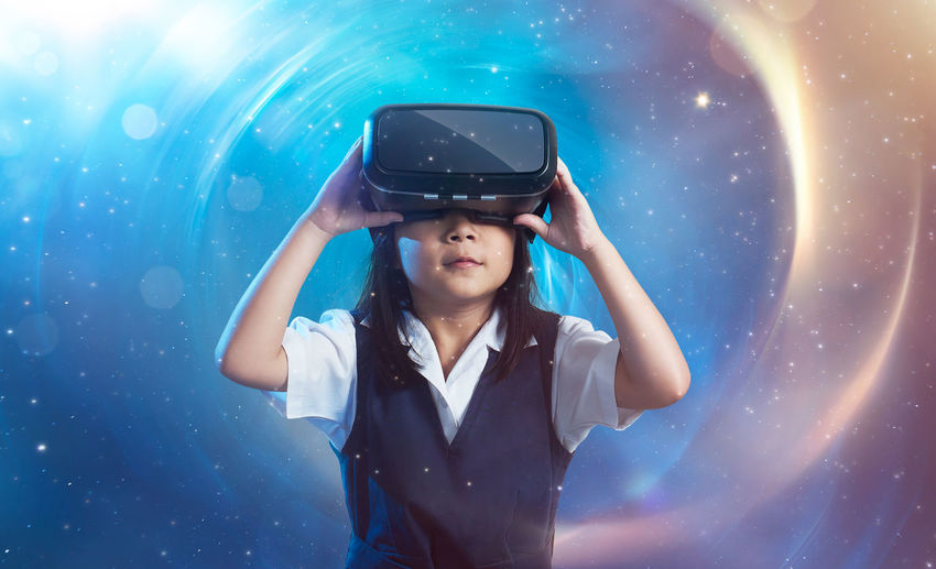 Girl using virtual reality headset against starry background
