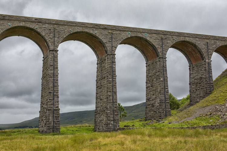 Low angle view of ribblehead viaduct against cloudy sky