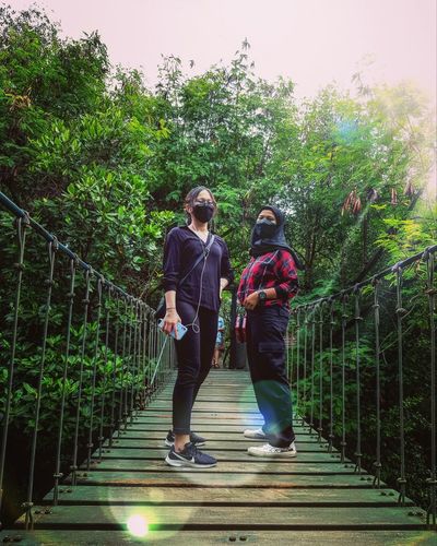 Rear view of people walking on footbridge