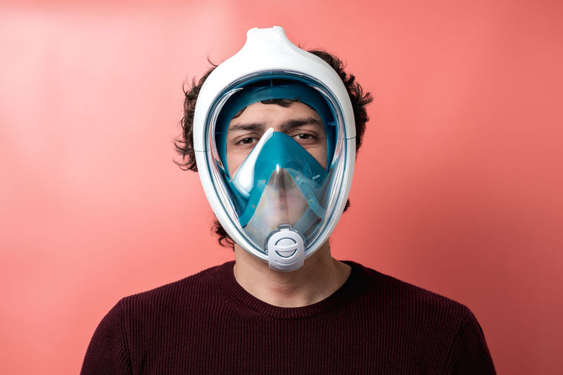 Man with underwater mask, covid-19 protection, coloured background
