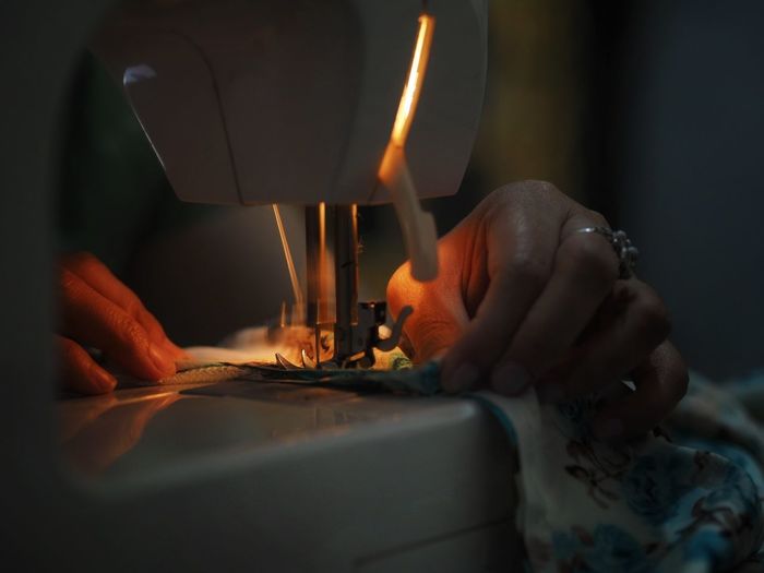 Close-up of woman stitching fabric on sewing machine