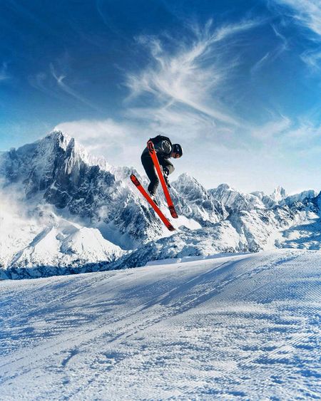 Man skiing on snow covered landscape against mountain