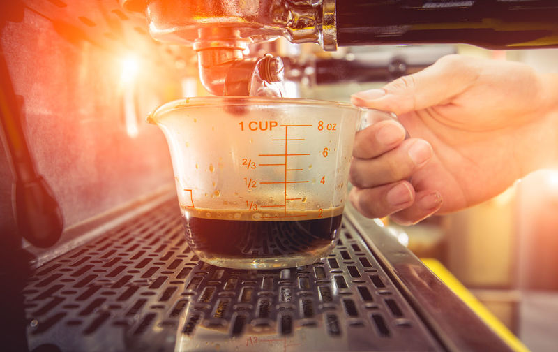 Close-up of hand holding glass of coffee