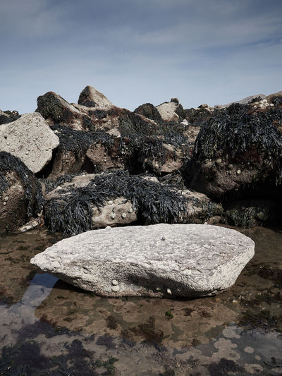 Rock formation on shore against sky