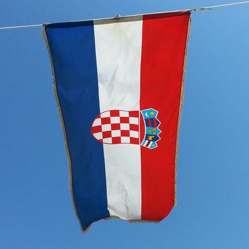 Low angle view of croatian flag against clear blue sky