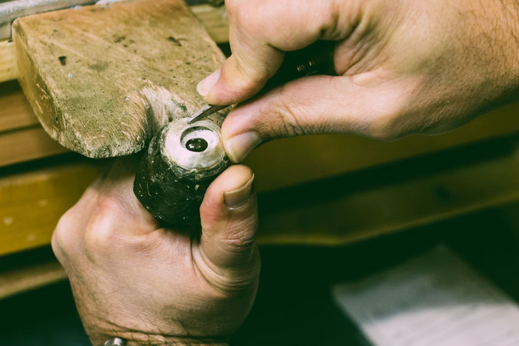 Cropped hands of man holding work tool in workshop