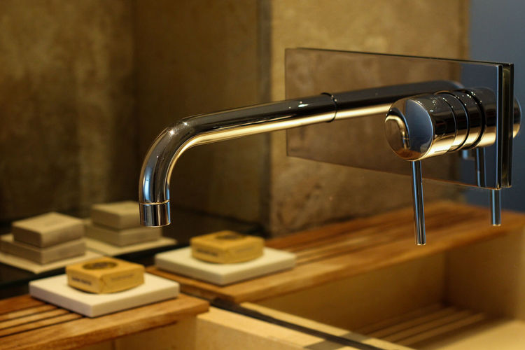 Close-up of tap against the mirror