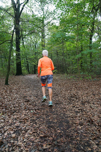 Rear view of woman jogging in forest
