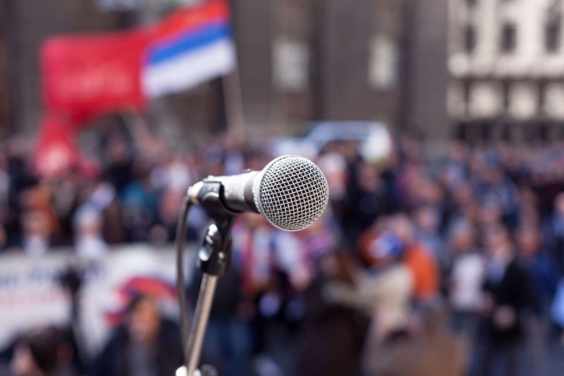 Close-up of a microphone against blurred people